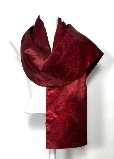 Red marbled  scarf on a white mannequin against a white background