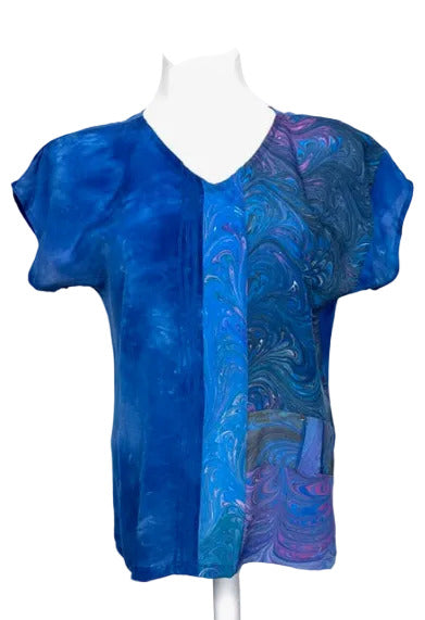 Blue marbled and dyed silk blouse on a mannequin against a white background