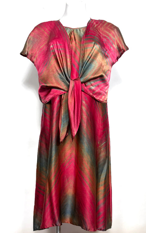 silk satin dress shibori dyed in tones of cranberry hunter green and soft gold on a mannequin against a white background