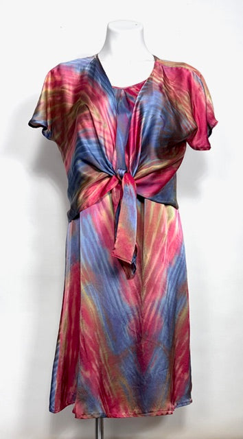 Colorful shibori dyed silk satin dress with an over jacket tied at the waist  on a mannequin against a white background