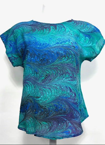 Blue and green marbled silk top on a white background