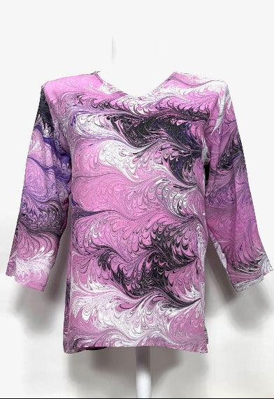 Pink and white marbled silk tunic on a mannequin against a white background