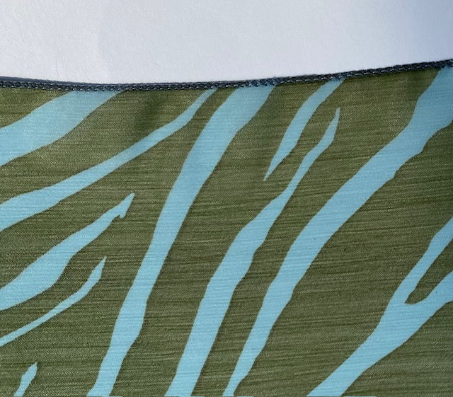 Close-up of edge of scarf fabric with blue and green zebra pattern