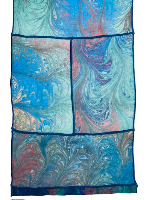 Marbled fabric with blue, green, and red patterns on a white background