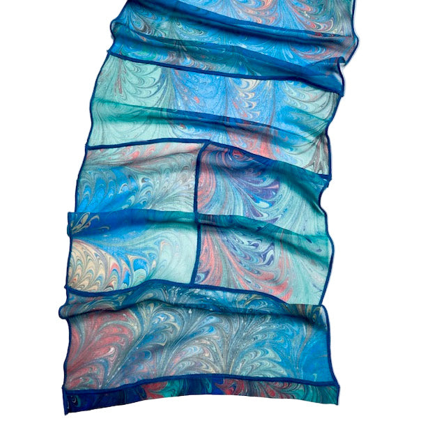 Marbled patterned fabric in blue and pink on a white background