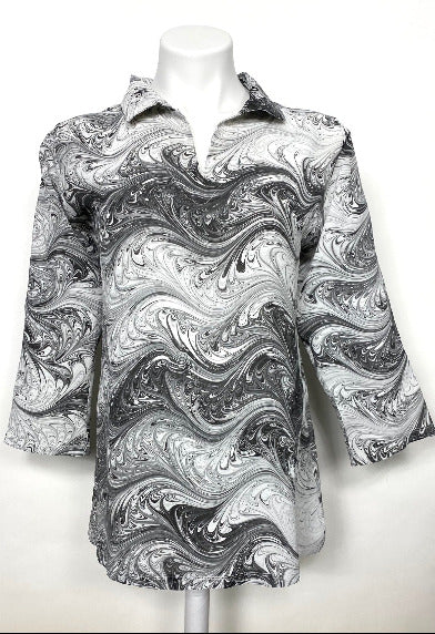 Mannequin wearing a black and white marbled silk collared top on a white background