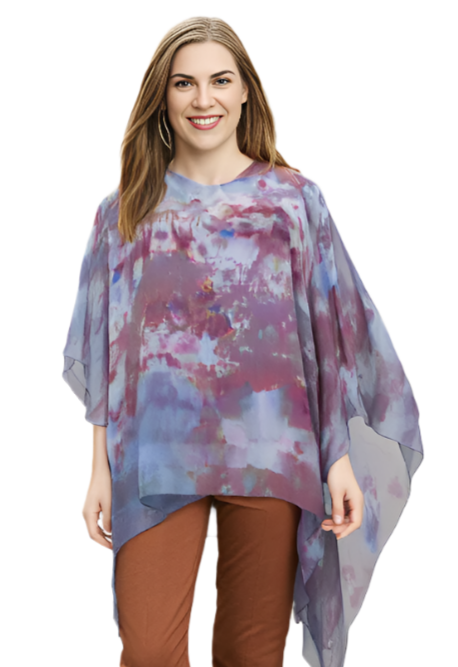 Woman wearing a colorful tie-dye poncho and brown pants on a white background