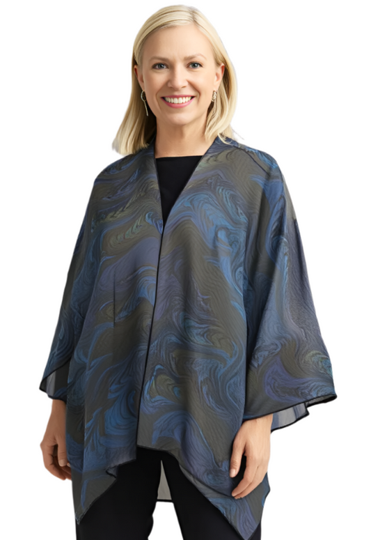 Woman wearing a blue and gray marble brown and blue sheer wrap/jacket against a plain background