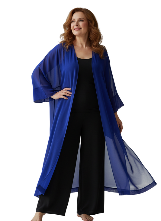 Woman wearing a blue kimono-style garment over a black outfit in a bright room.
