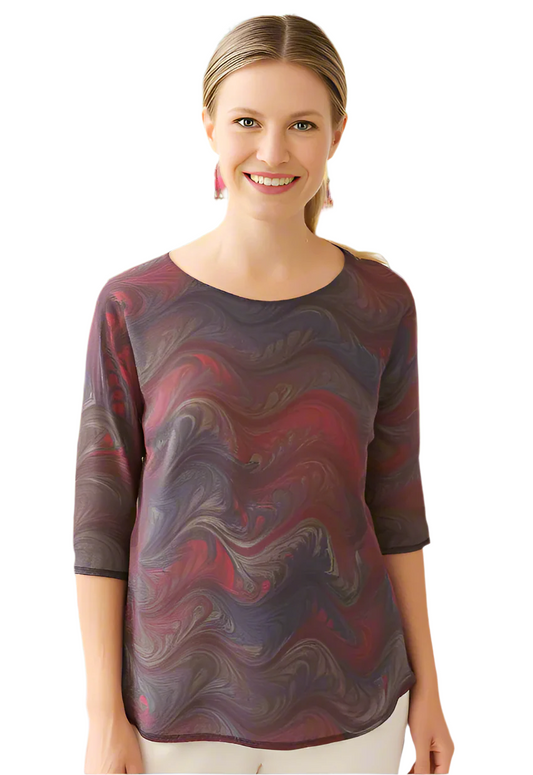 Woman wearing a deep brown with red hand marbled  top against a white background