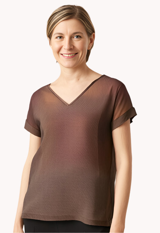 Woman wearing a brown tie dye blouse and black pants against a white background
