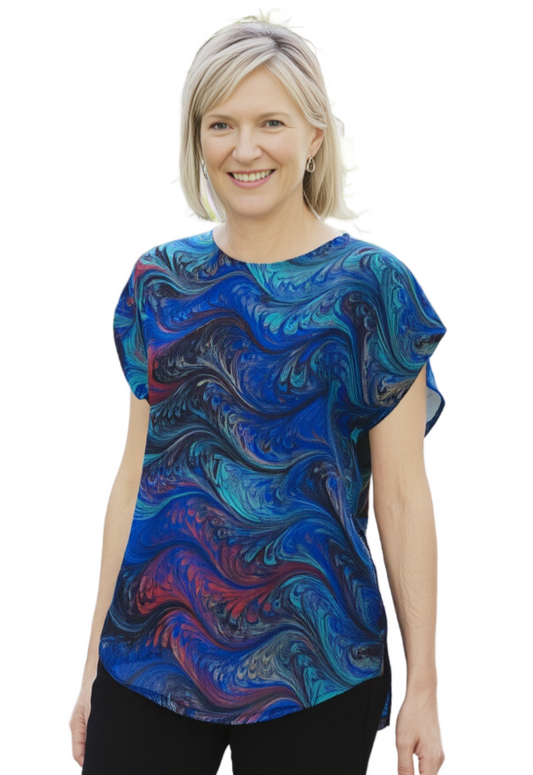 Woman wearing a blue and red marbled patterned top on a white background