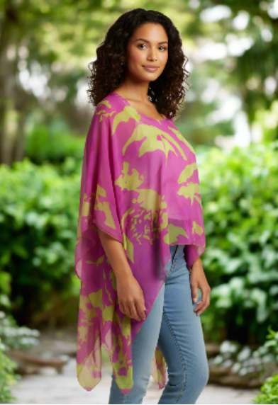 Woman wearing a pink and green abstract patterned poncho  with jeans  on a beige background