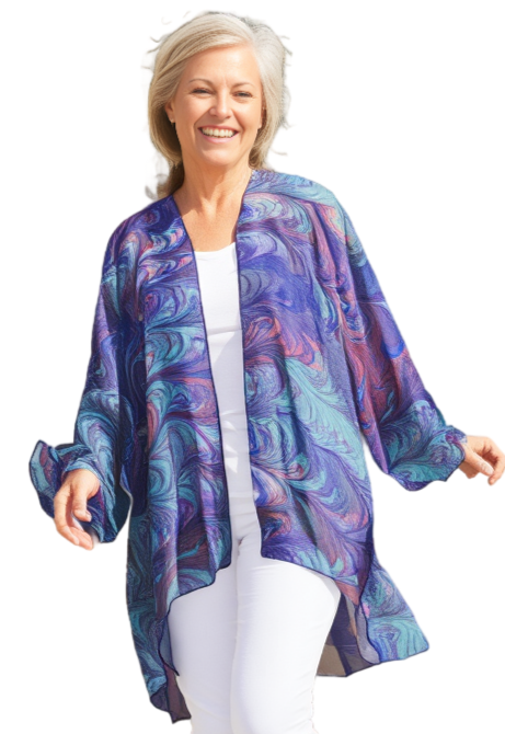Woman wearing a colorful hand marbled kimono-style jacket over a white outfit on a white background