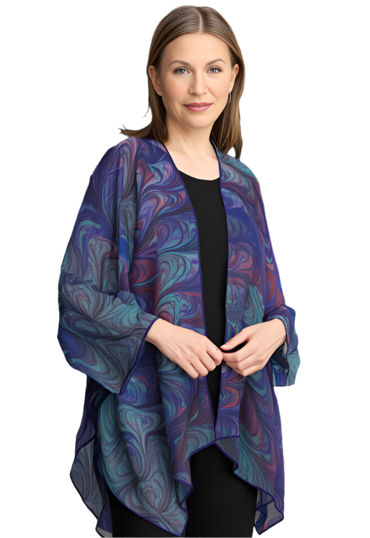 Woman wearing a marbled blue, green purple and red wrap jacket against a white background
