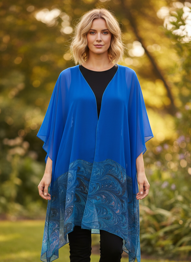 woman in outdoor setting wearing a bright turquoise and marbled ruana 