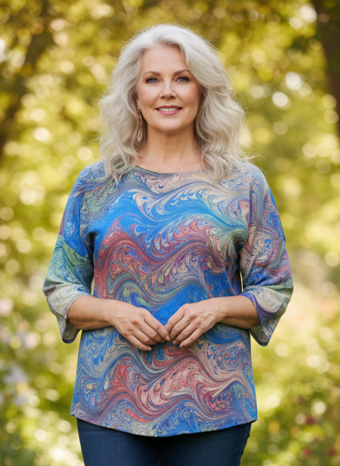 woman wearing brightly marbled silk top in an outdoor setting