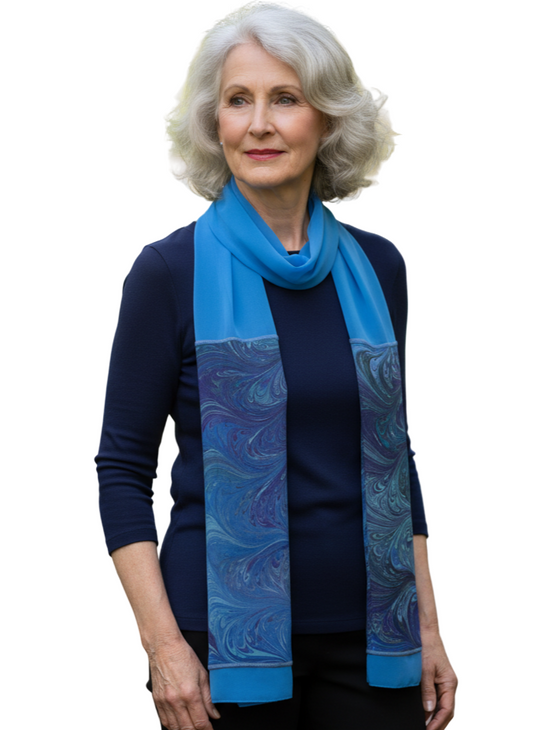 Woman wearing a blue dyed and marbled silk scarf against a white background