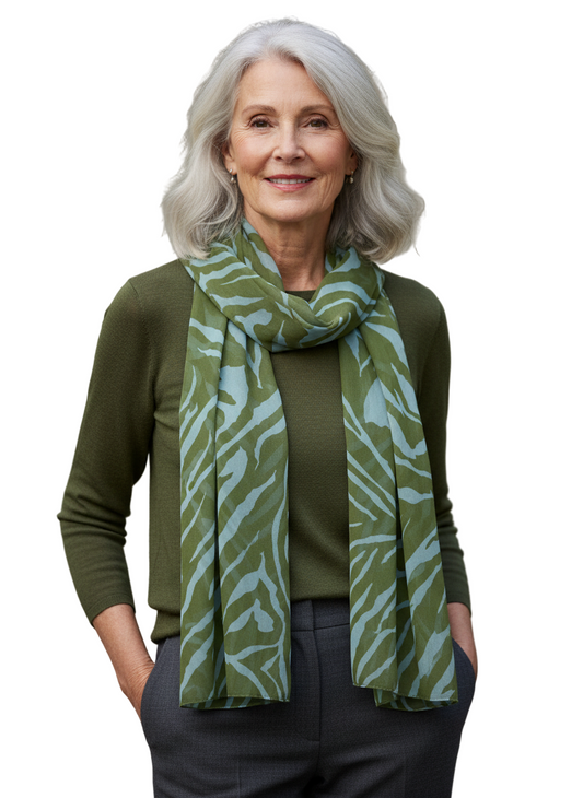 Woman wearing a green patterned scarf against a neutral background