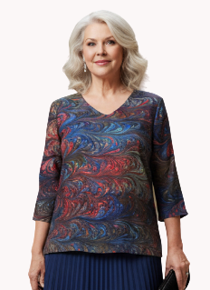 Woman in a marbled silk tunic and blue pleated skirt standing in an art gallery.