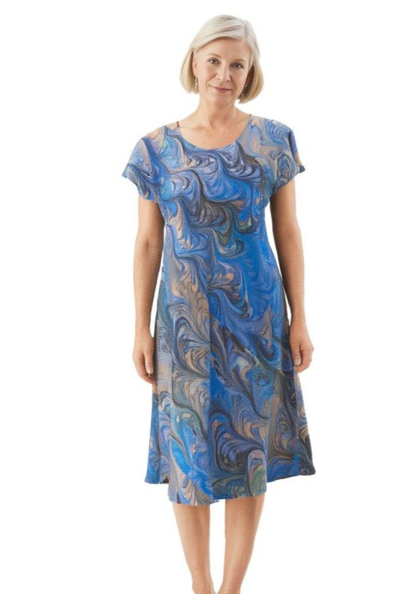 Woman wearing a bias, cut celery, gray marbled dress against the white background