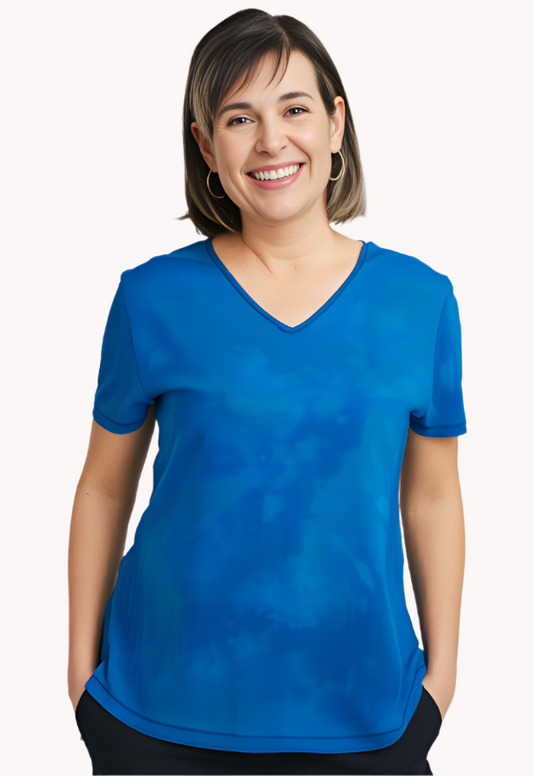 Woman wearing a blue green hand dyed silk shirt against a white background