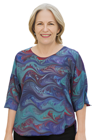 Woman wearing a colorful marbled silk blouse and black pants against a white background