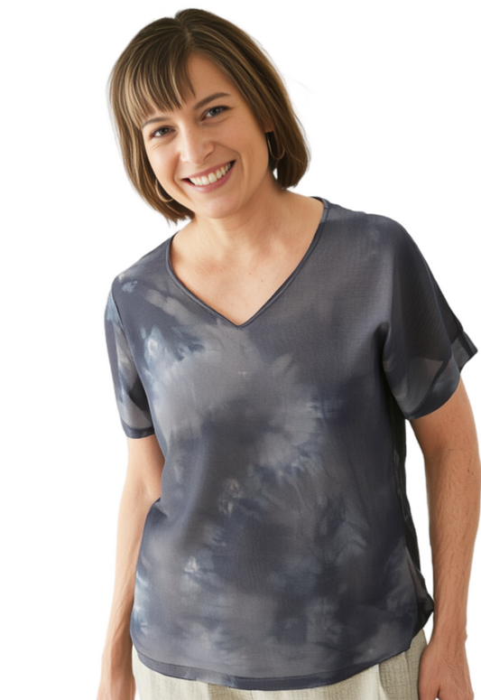 Woman wearing a gray/charcoal silk tie-dye shirt on a white background