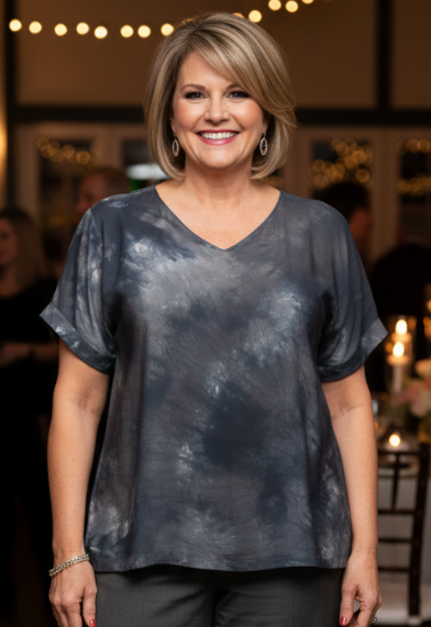 Woman wearing a gray hand-dyed silk shirt and gray pants at a party