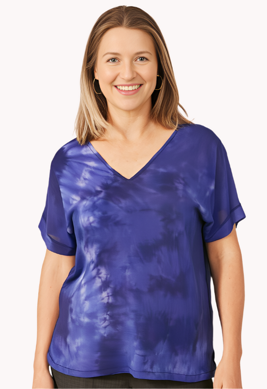 Woman wearing a blue tie-dye shirt against a white background