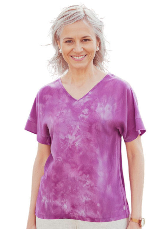 Woman wearing a rosy mauve silk dyed t shirt on a white background