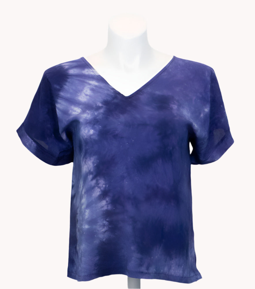 Blue tie-dye silk t shirt on a mannequin against a white background