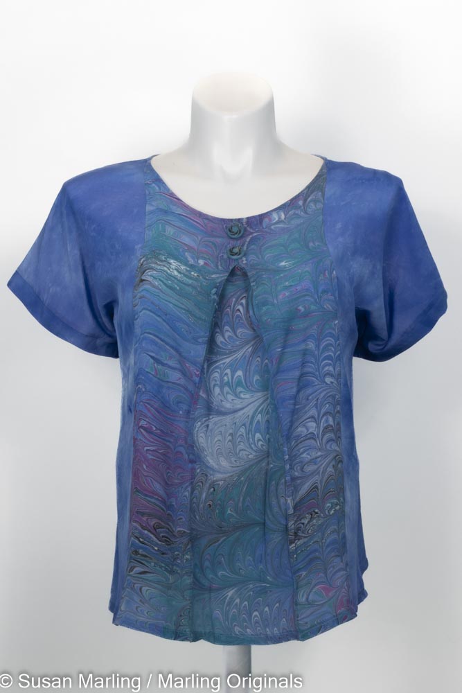 blue silk top with marbled pleated inset in jewels. round neck. short sleeves