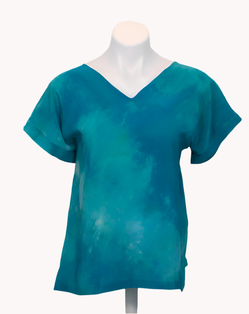 Teal tie-dye silk t shirt on a mannequin against a white background
