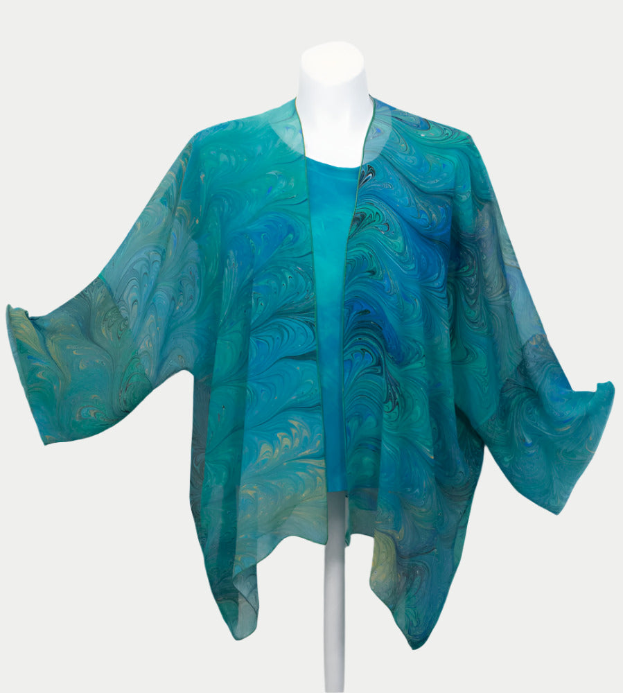Blue and green marbled silk sheer wrap/jacket on a mannequin against a white background