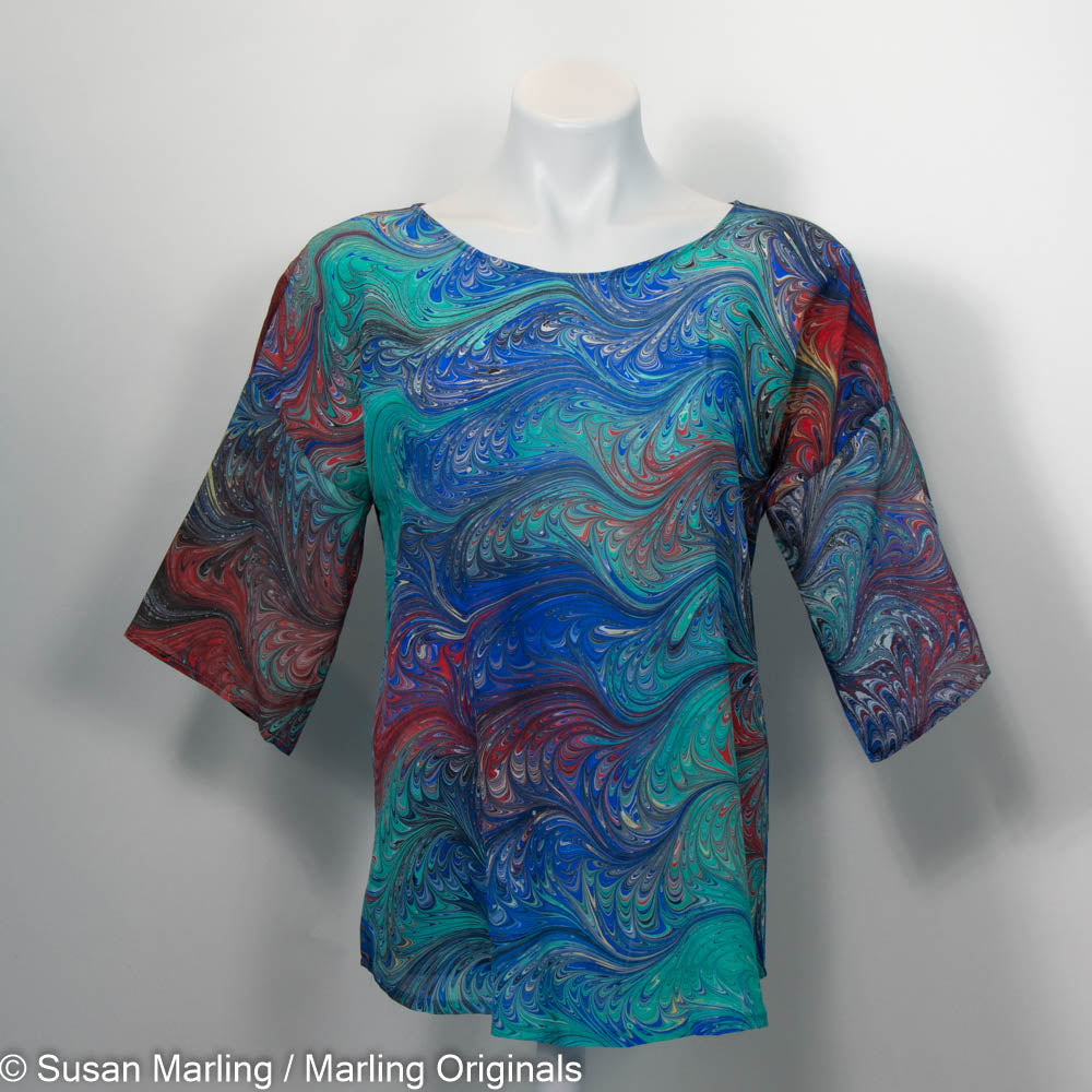 Silk round neck top in vibrant marbled pattern of greens, blues, red, yellow