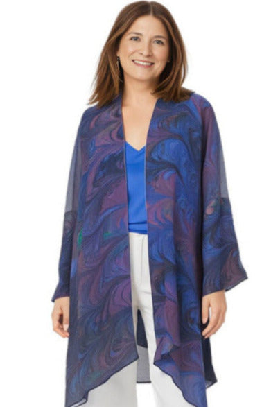 Woman wearing a blue patterned kimono-style garment over a blue top and white pants on a white background