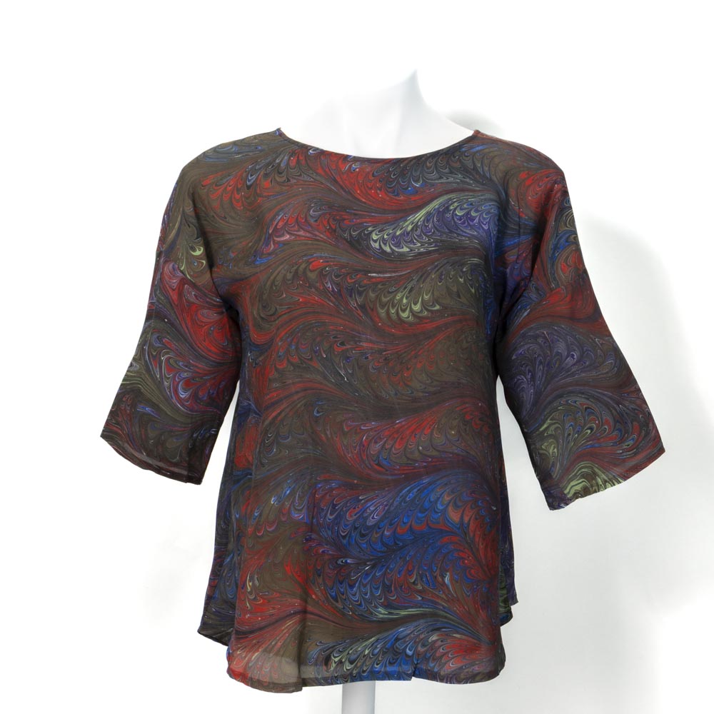 Colorful hand marbled silk blouse on a white mannequin against a white background