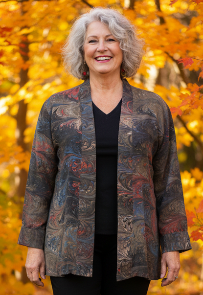 Woman wearing a brown marbled swing jacket standing in an autumn forest with colorful leaves