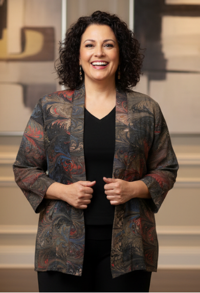 Woman wearing a brown marbled silk jacket and black pants in an indoor setting