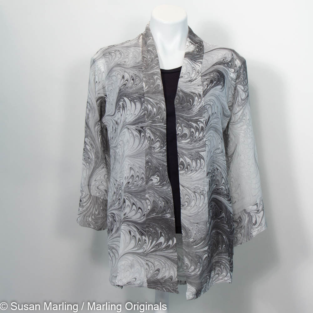 Sheer kimono jacket in marbled pattern of grey, black and white tones.