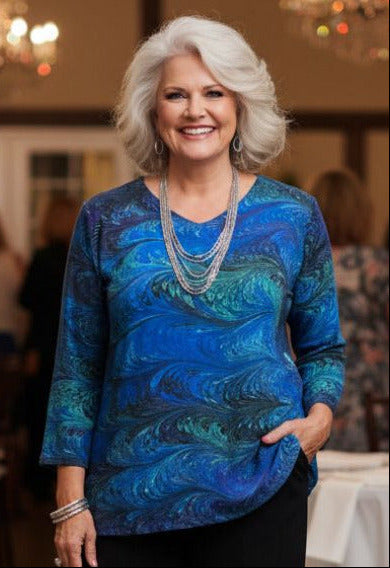 Woman wearing a blue marbled silk tunic in a wedding reception setting