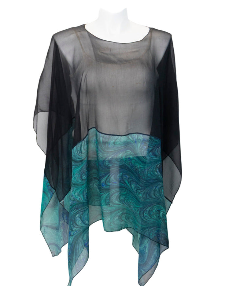 Sheer black and teal marbled poncho on a white background
