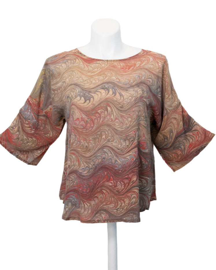 Marbled silk blouse on a mannequin against a white background