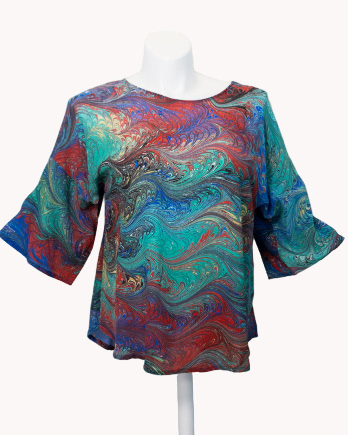 Colorful marbled silk  top on a white mannequin against a white background