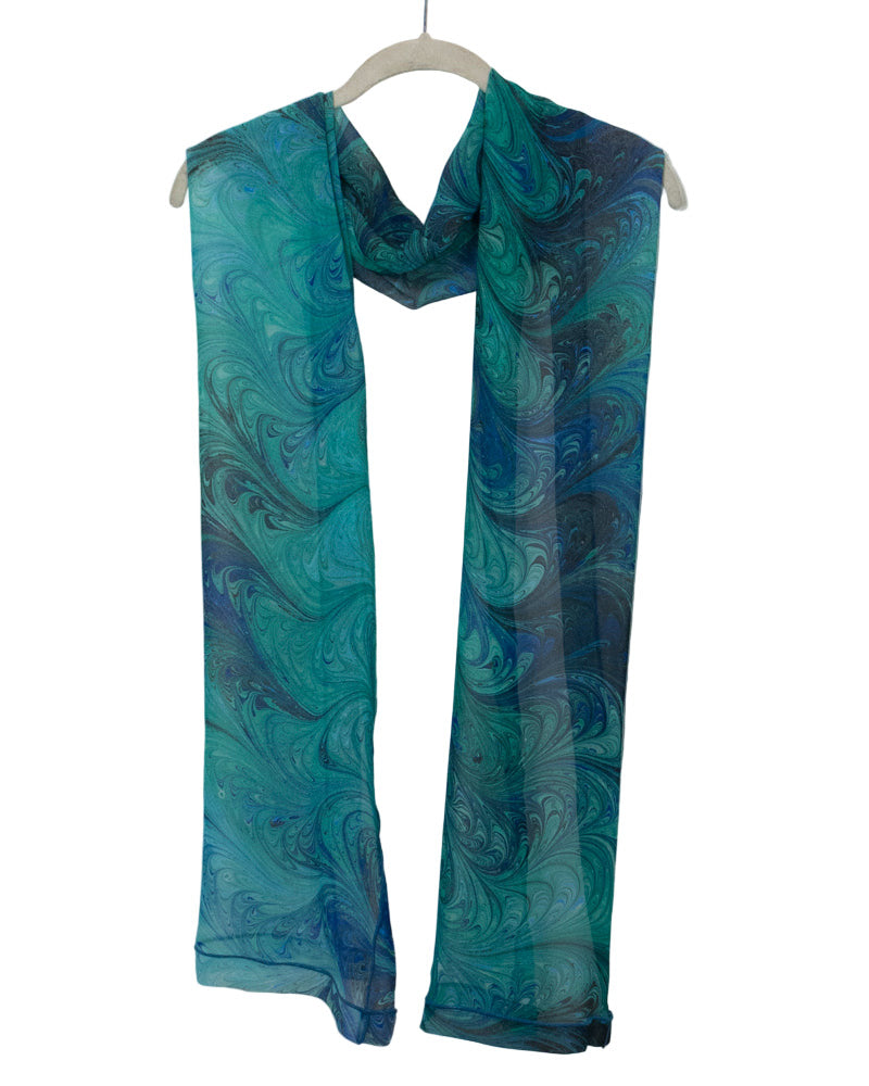 Blue and green marbled scarf on a white hanger against a white background