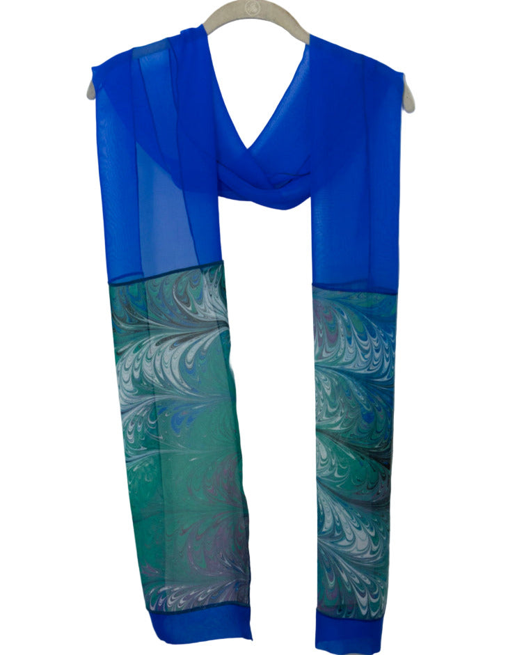 Blue and marbled jewels silk scarf on a hanger against a white background