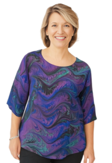Woman wearing a hand marbled silk top and black pants on a white background