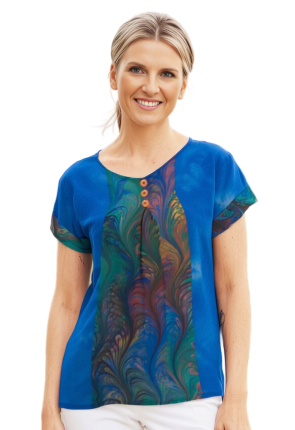 Woman wearing a hand dyed blue silk top with colorful marbled pattern inset on a white background