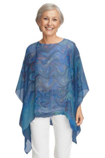Woman wearing a sheer blue marbled silk poncho and white pants on a white background